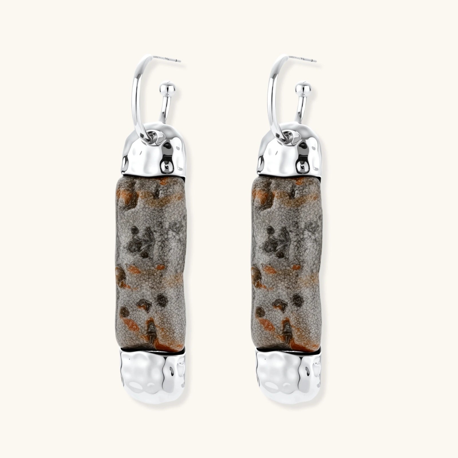 Cylindrical resin earrings with gray stone-like patterns and silver-toned metal caps, hanging against white background