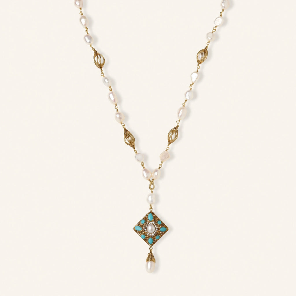 Y-shaped necklace with freshwater pearls, gold filigree stations, and ornate diamond-shaped centerpiece with pearl drop
