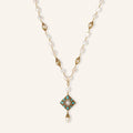 Y-shaped necklace with freshwater pearls, gold filigree stations, and ornate diamond-shaped centerpiece with pearl drop