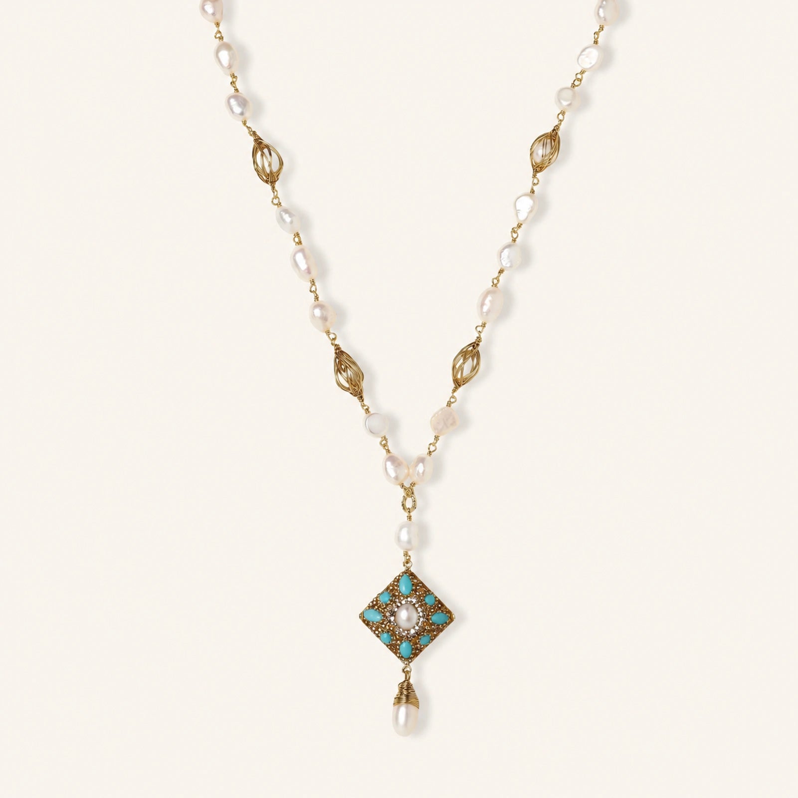 Y-shaped necklace with freshwater pearls, gold filigree stations, and ornate diamond-shaped centerpiece with pearl drop